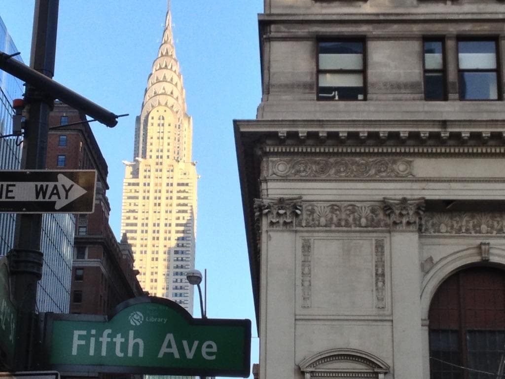 A Fifth Avenue street sign with the Chrysler Building beyond